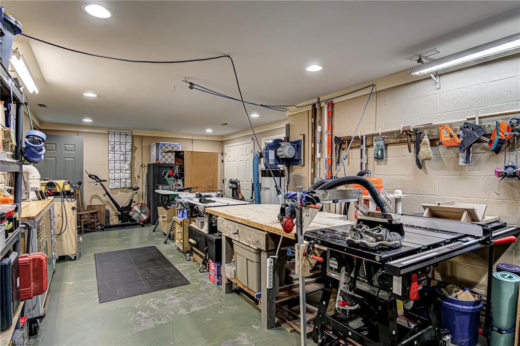 8065 Lasater Road Clemmons, NC 27012 - Photo 29 of 39 Basement, currently used as a workshop. All Shop vac equipment does not convey. This room is heated and cooled and has a ceiling with recessed lighting. It could easily be make into a playroom or other finished sqft. It is not included in the sqft.