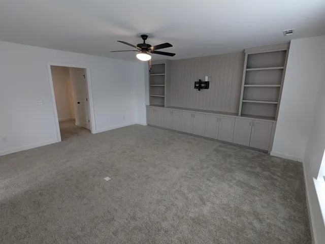 an empty room with windows and cabinet