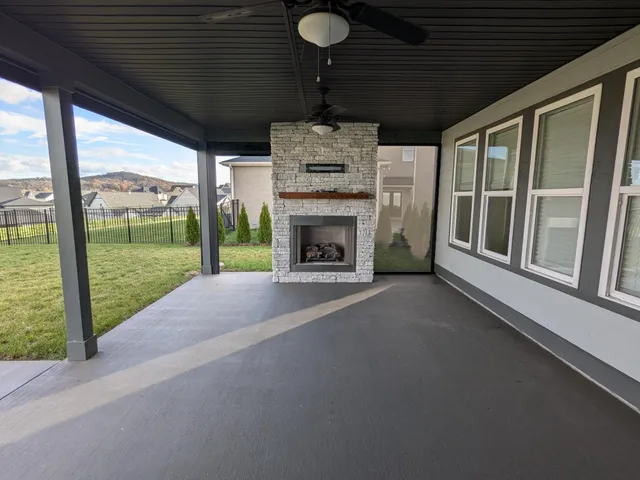 a view of an empty room with a fireplace and a window