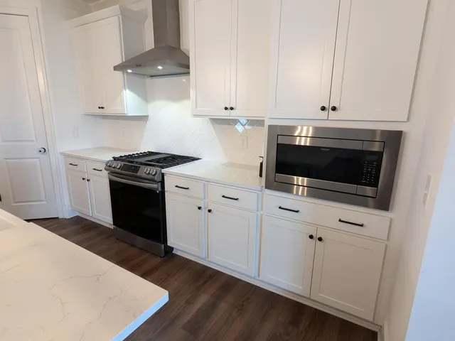 a kitchen with stainless steel appliances a stove a microwave and cabinets