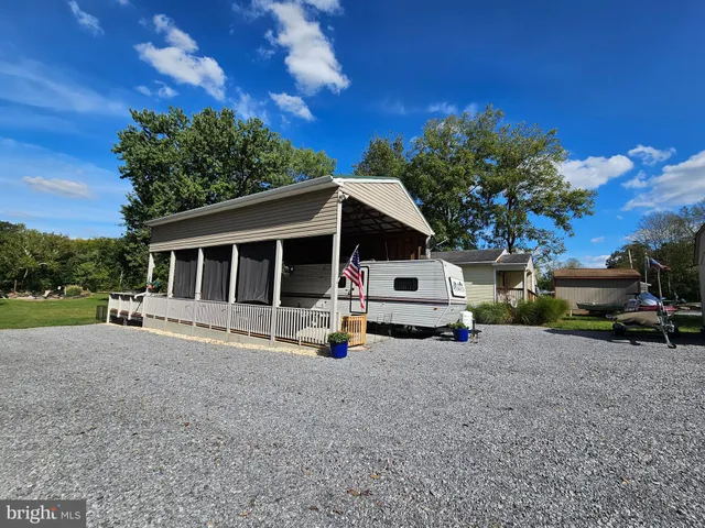 a white house covered with tall trees