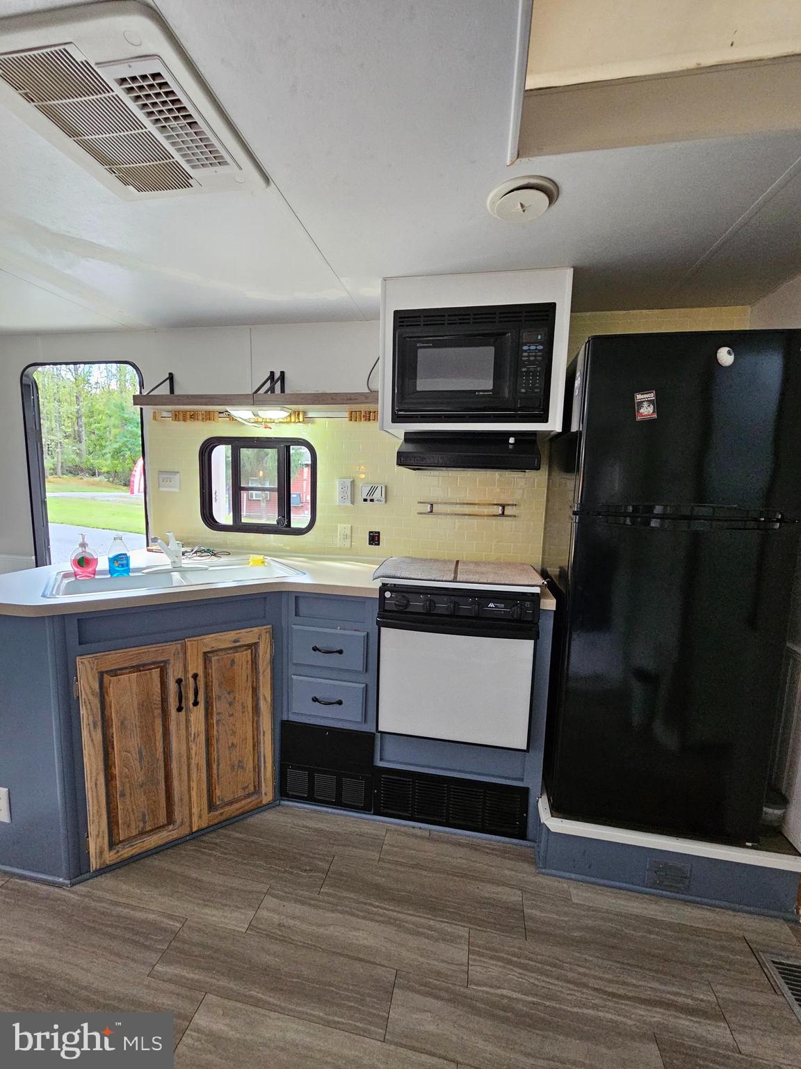 56 Boo Boo Boulevard Falling Waters, WV 25419 - Photo 29 of 48 a living room with stainless steel appliances kitchen island granite countertop a refrigerator a stove a microwave oven with white cabinets and wooden floor