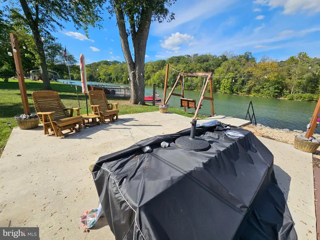 a view of a patio with a table chairs and a fire pit