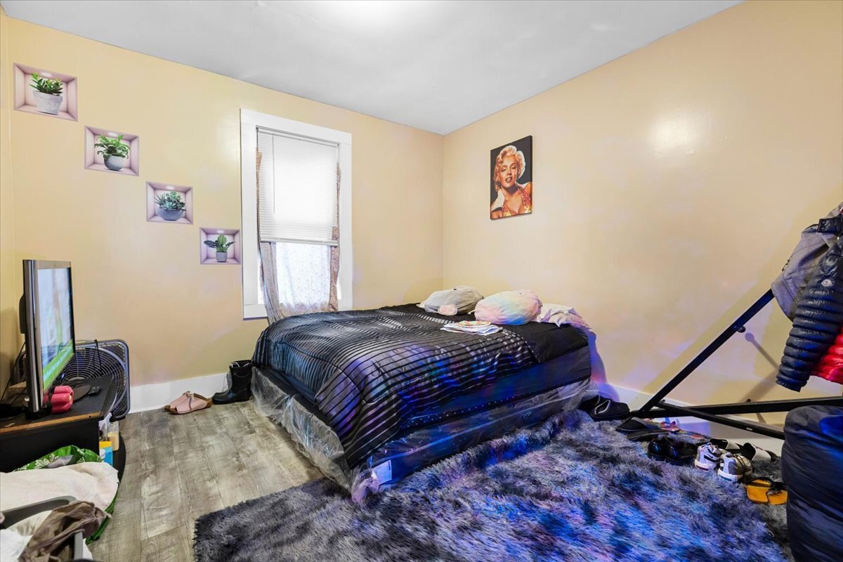 205 Smith Street Bridgeport, CT 06607 - Photo 11 of 28 a bedroom with a bed and wooden floor