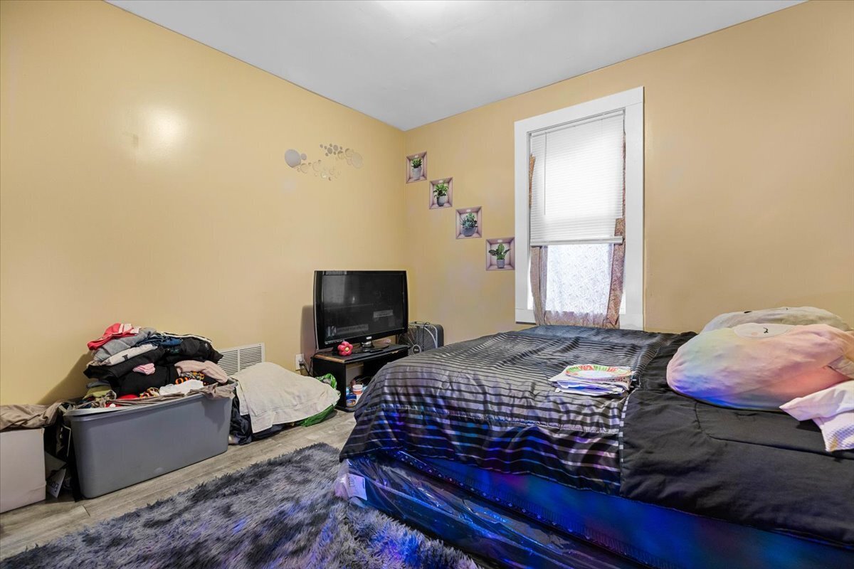 205 Smith Street Bridgeport, CT 06607 - Photo 12 of 28 a bedroom with a bed and flat screen tv