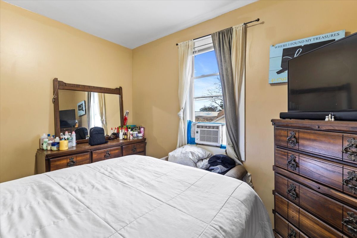 205 Smith Street Bridgeport, CT 06607 - Photo 19 of 28 a bedroom with a bed and a flat tv screen on a dresser