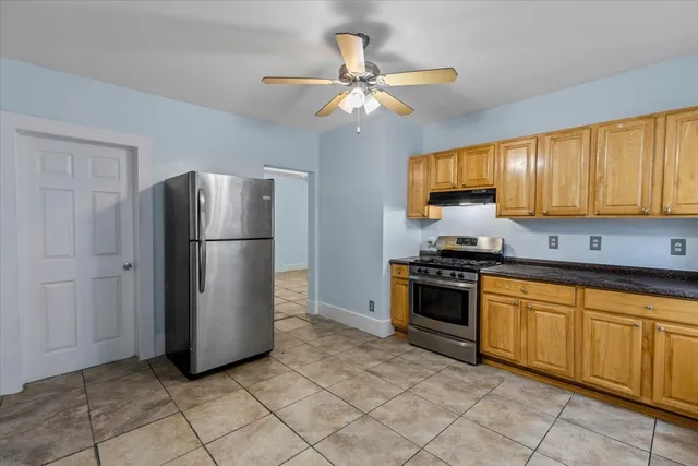 a view of kitchen with stainless steel appliances granite countertop cabinets and window