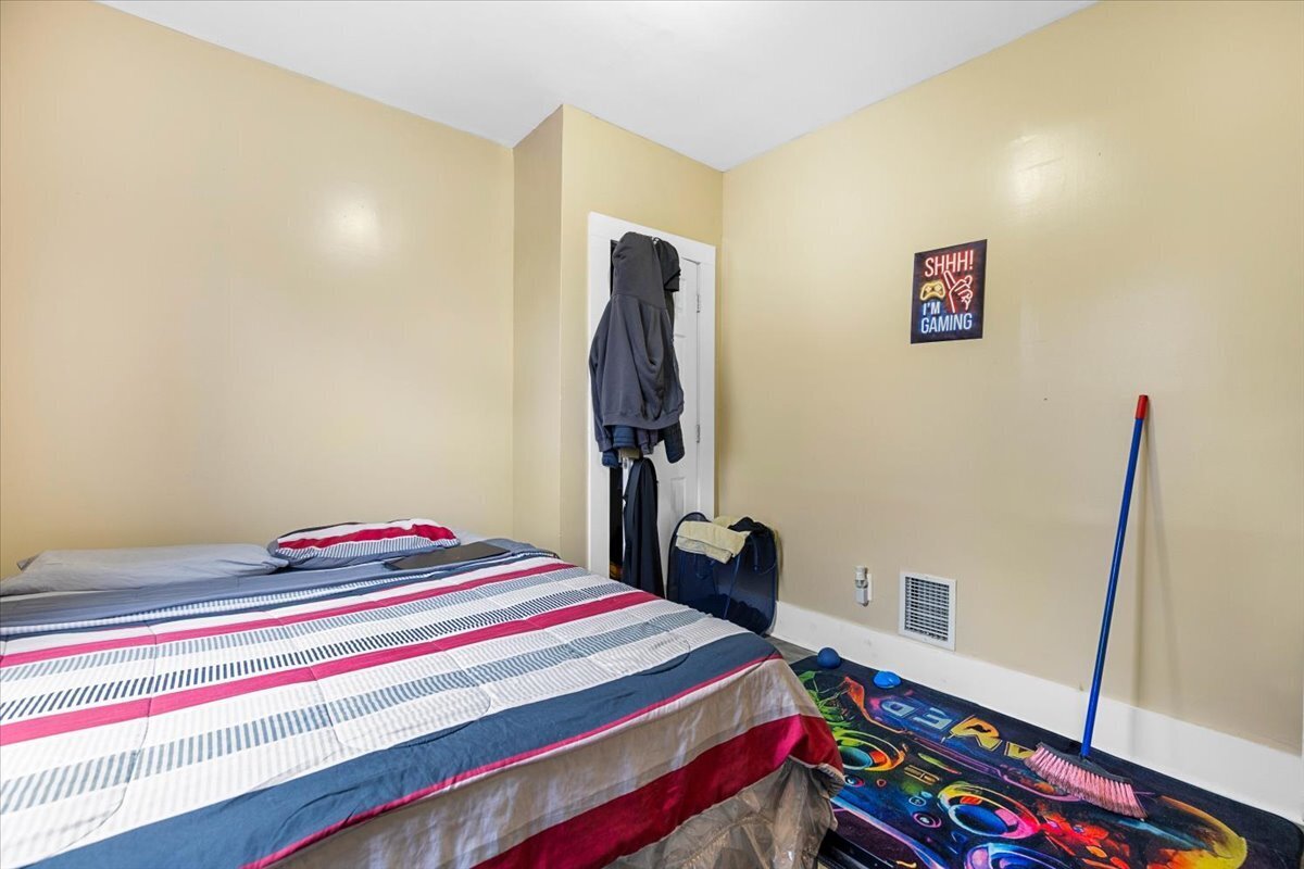 205 Smith Street Bridgeport, CT 06607 - Photo 9 of 28 a bedroom with a bed and a wooden floor