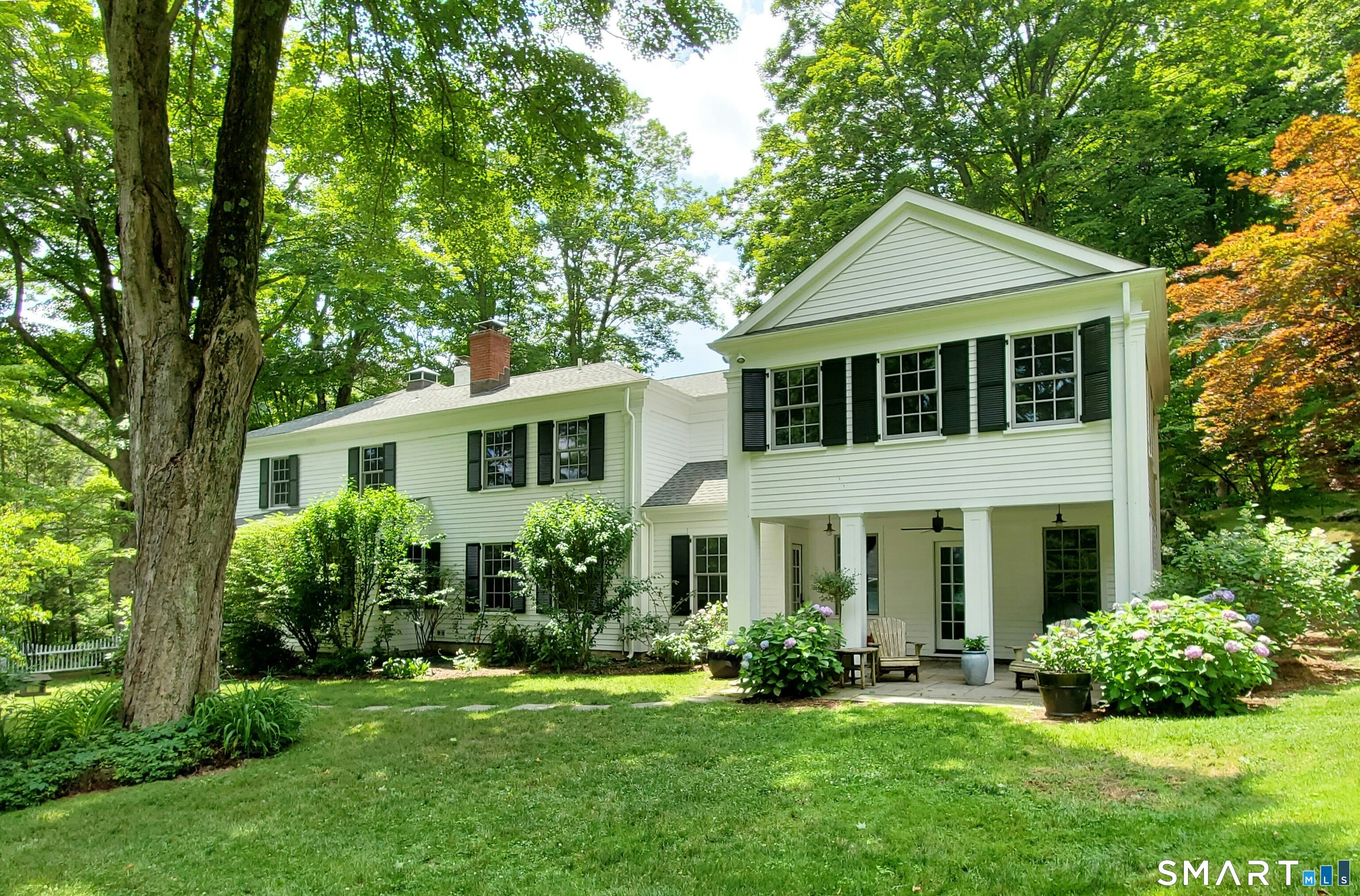 a front view of a house with a yard and potted plants