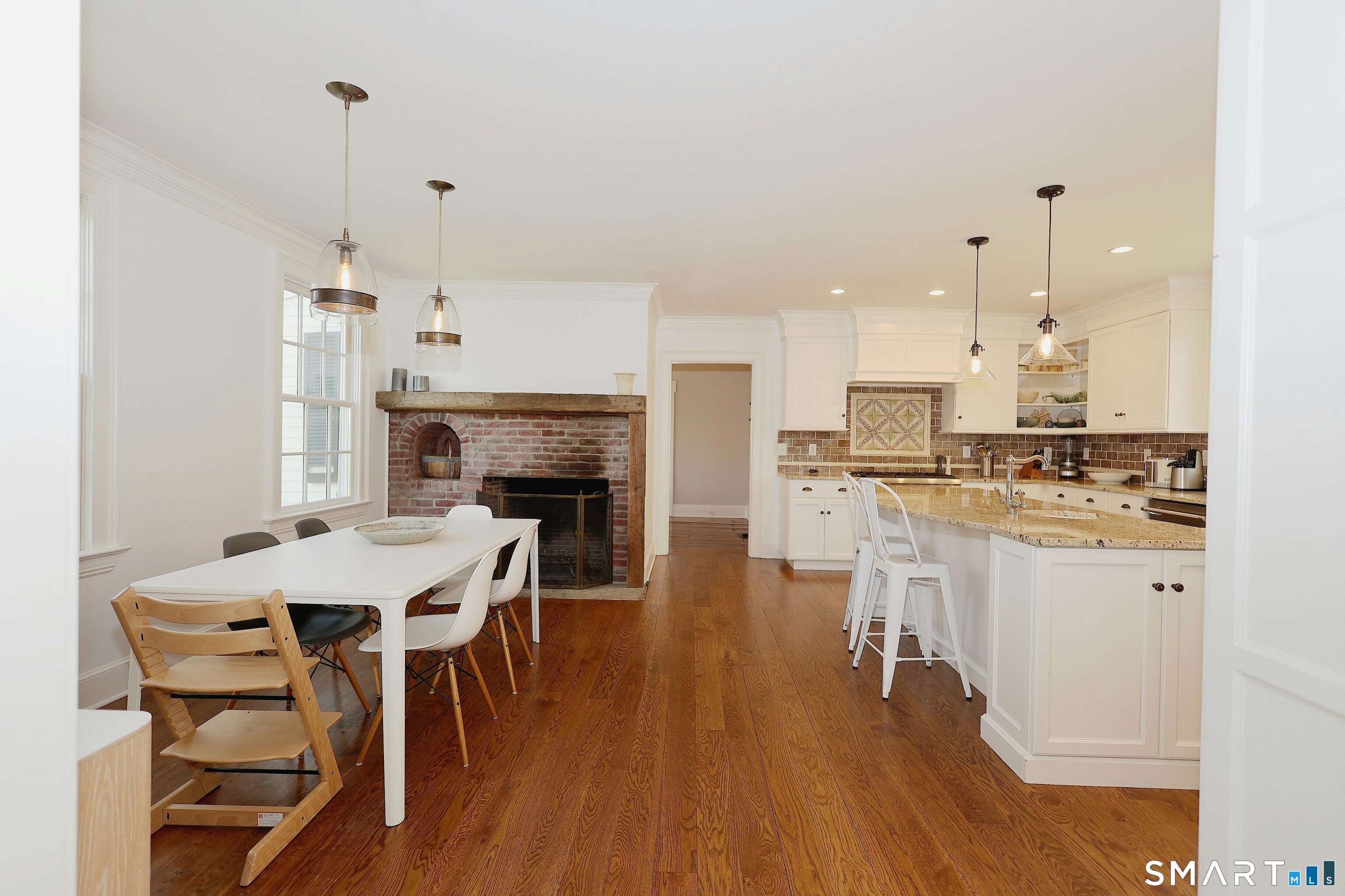 219 Bennetts Farm Road Ridgefield, CT 06877 - Photo 12 of 40 a open kitchen with stainless steel appliances granite countertop a stove a refrigerator a kitchen island a sink a stove and white cabinets with wooden floor