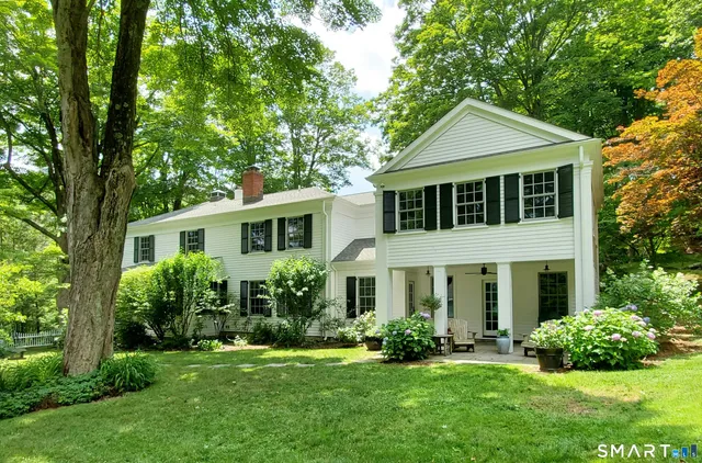 a front view of a house with a yard and potted plants