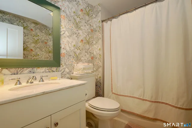 a bathroom with a sink a toilet and shower curtain