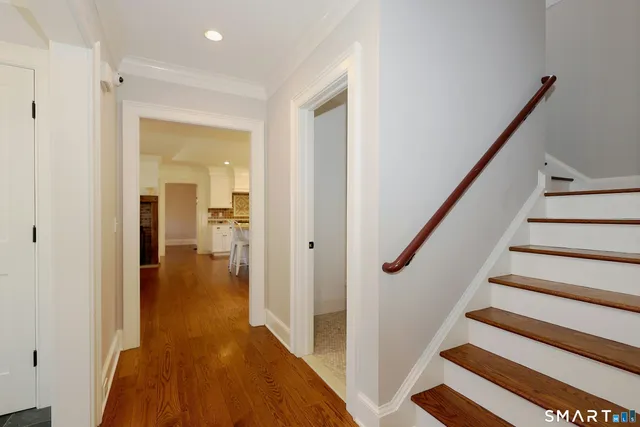 a view of a hallway with wooden floor and staircase