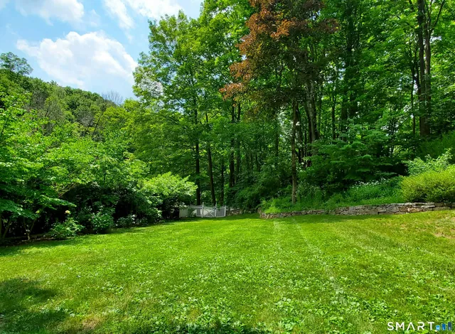 a view of green field with trees in the background