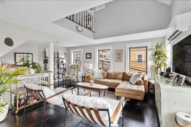 a living room with furniture wooden floor and a flat screen tv