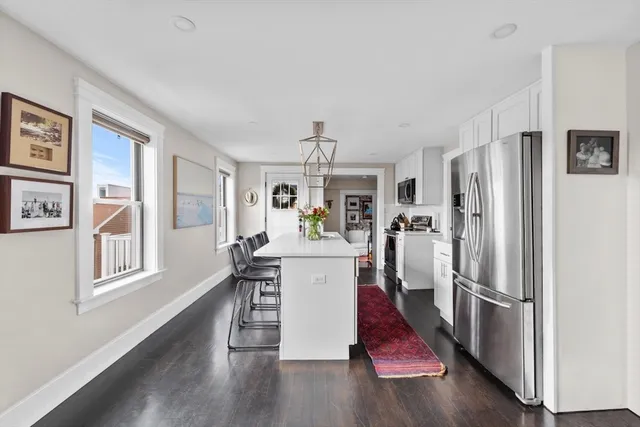 a view of kitchen with furniture refrigerator and wooden floor