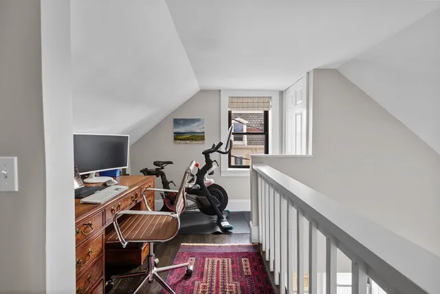 a view of a workspace with wooden floor and white cabinet