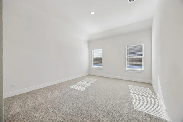 a view of an empty room with wooden floor and closet