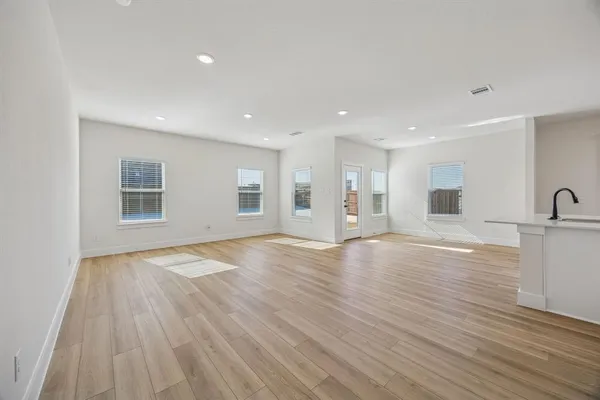 a view of empty room with wooden floor and window