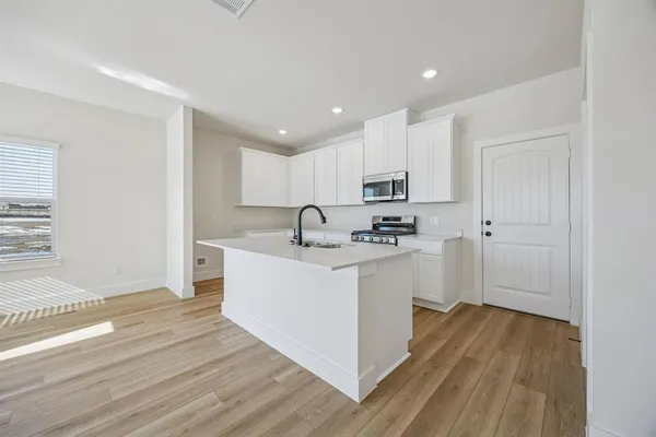 a view of kitchen with wooden floor and electronic appliances