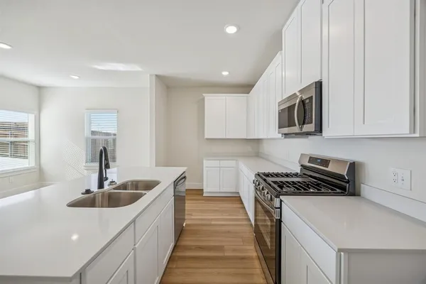 a view of kitchen with sink microwave and refrigerator