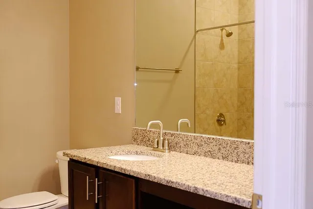a bathroom with a granite countertop sink and a mirror