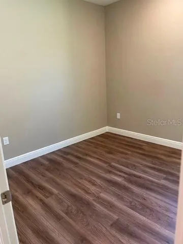 a view of an empty room with wooden floor