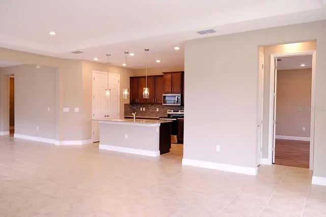 a view of kitchen with refrigerator sink and cabinets
