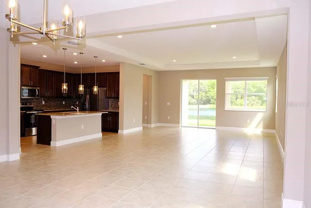 a view of large kitchen with a large counter top stainless steel appliances and cabinets
