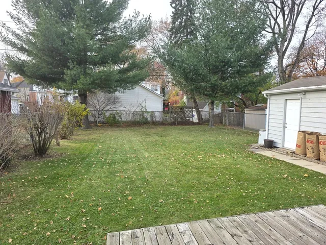 a view of a yard with a house and a large tree