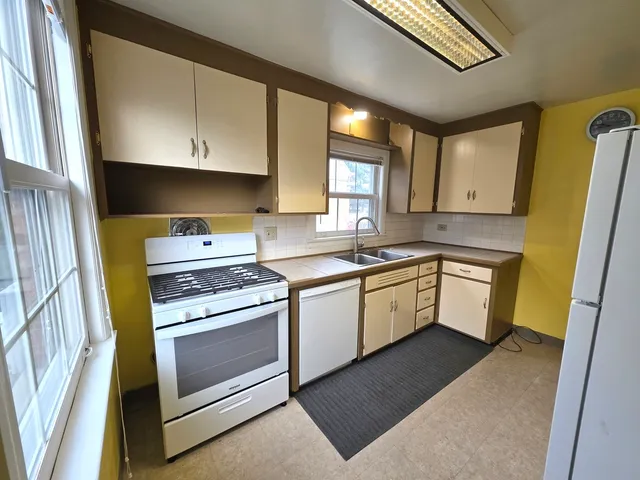 a kitchen with a stove sink and cabinets