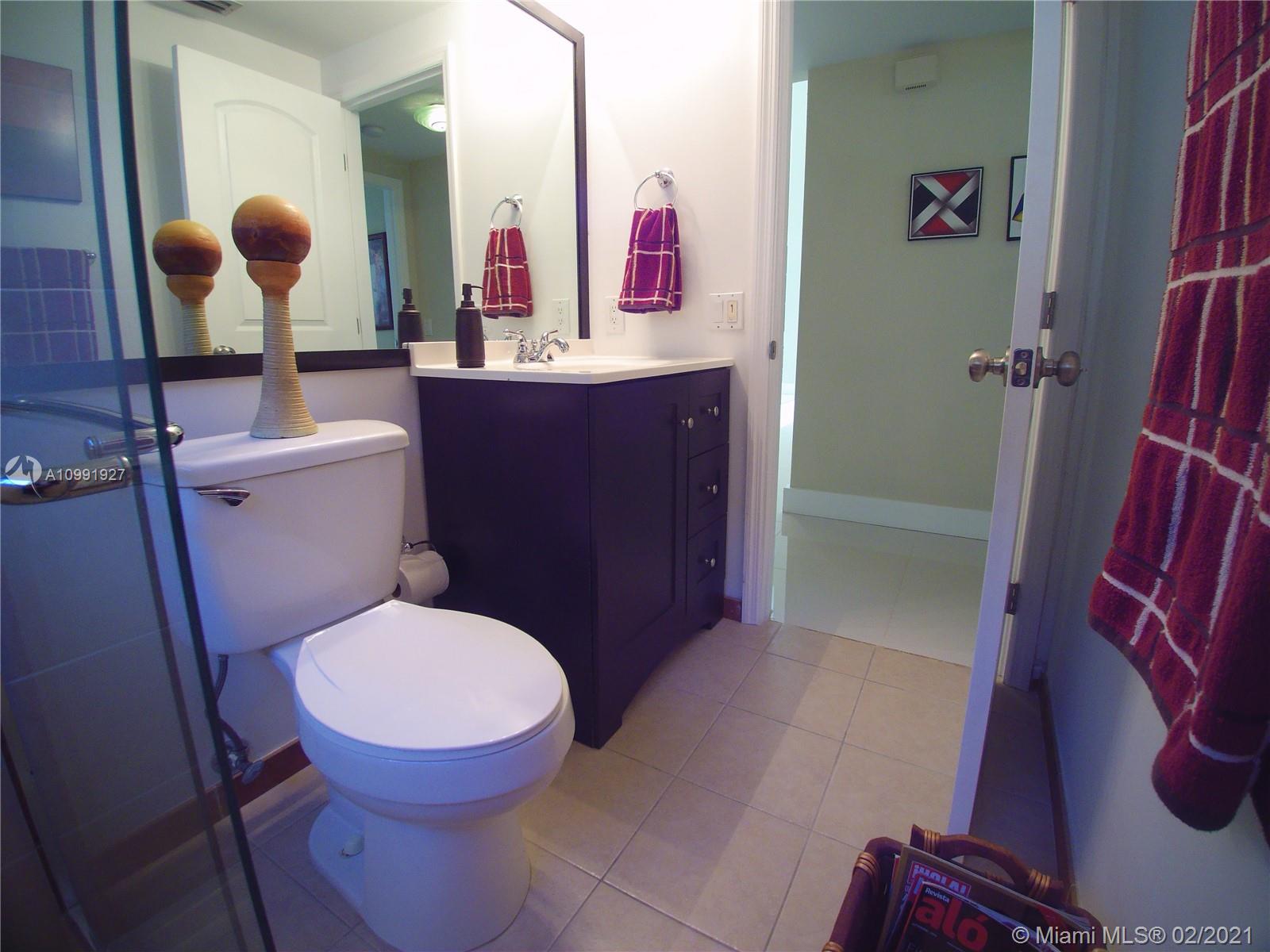 1055 San Luis Rey Weston, FL 33326 - Photo 14 of 36 a bathroom with a toilet mirror on vanity and shower