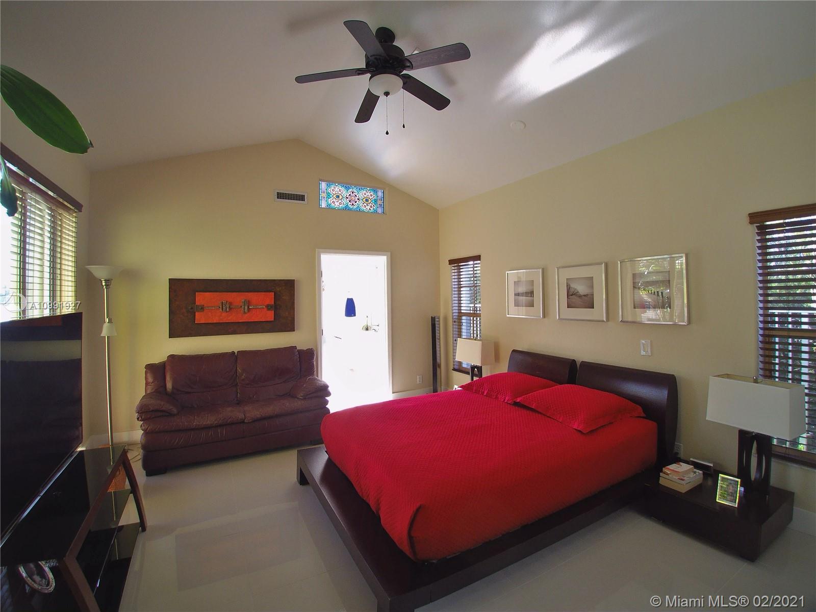 1055 San Luis Rey Weston, FL 33326 - Photo 15 of 36 a bedroom with a bed and a chandelier