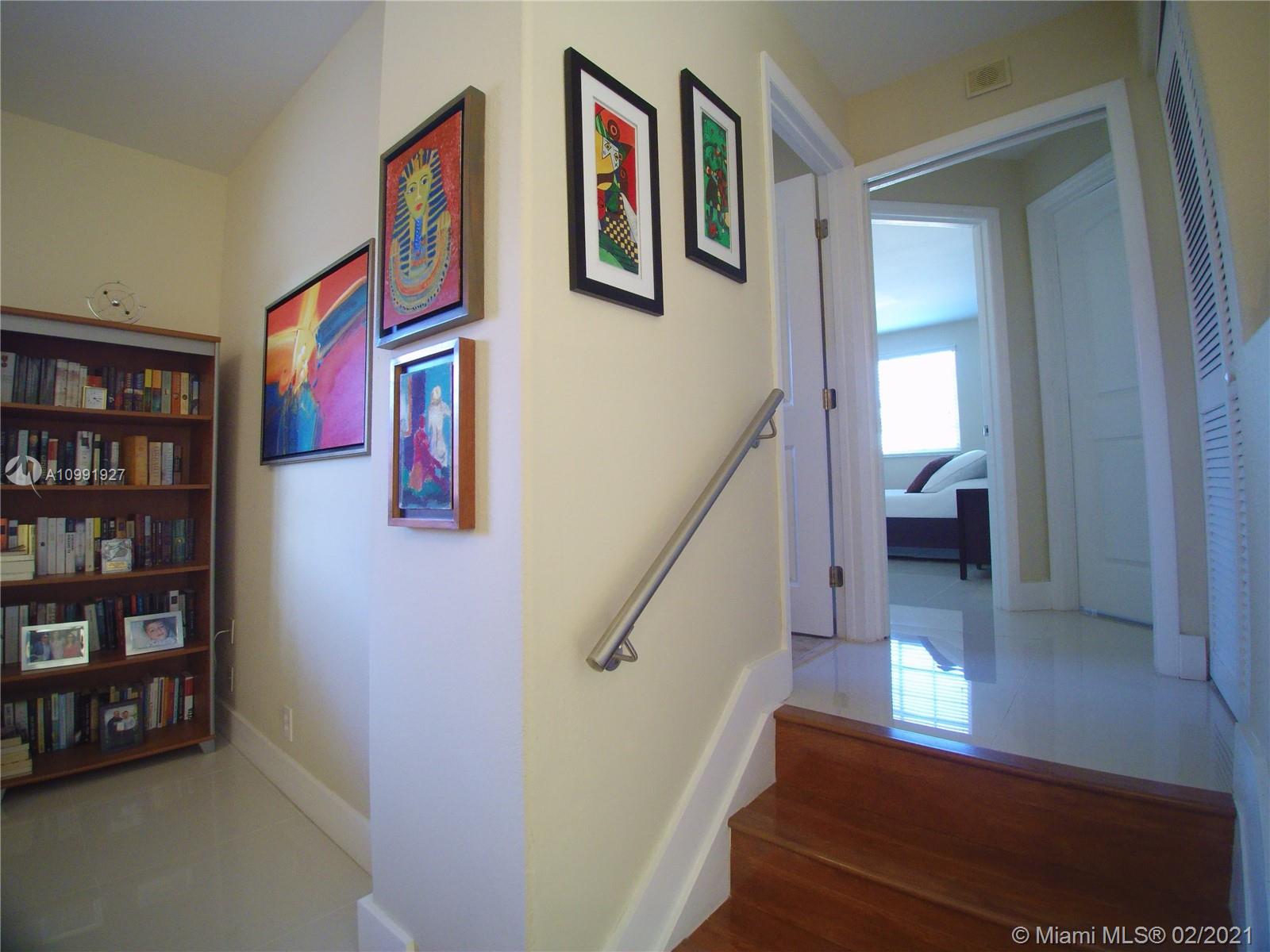 1055 San Luis Rey Weston, FL 33326 - Photo 19 of 36 a view of a hallway with wooden floor and staircase