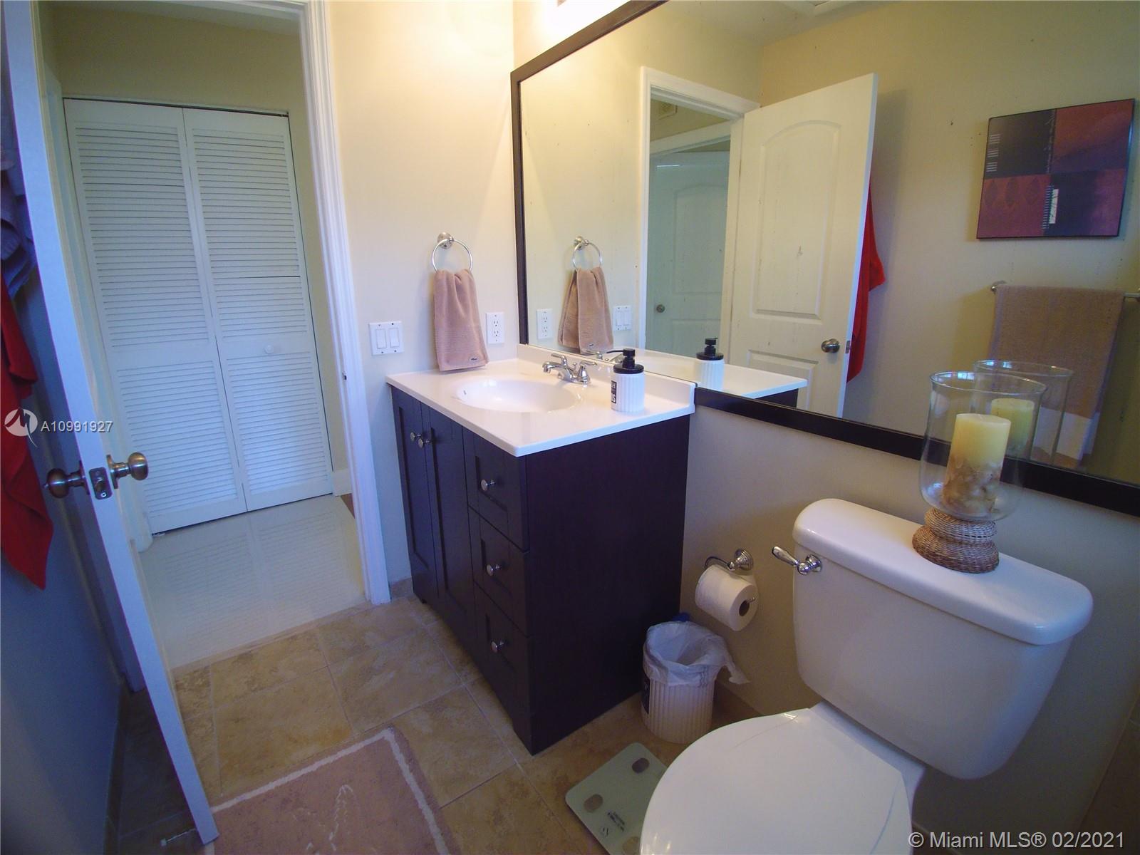 1055 San Luis Rey Weston, FL 33326 - Photo 23 of 36 a bathroom with a sink vanity mirror and toilet