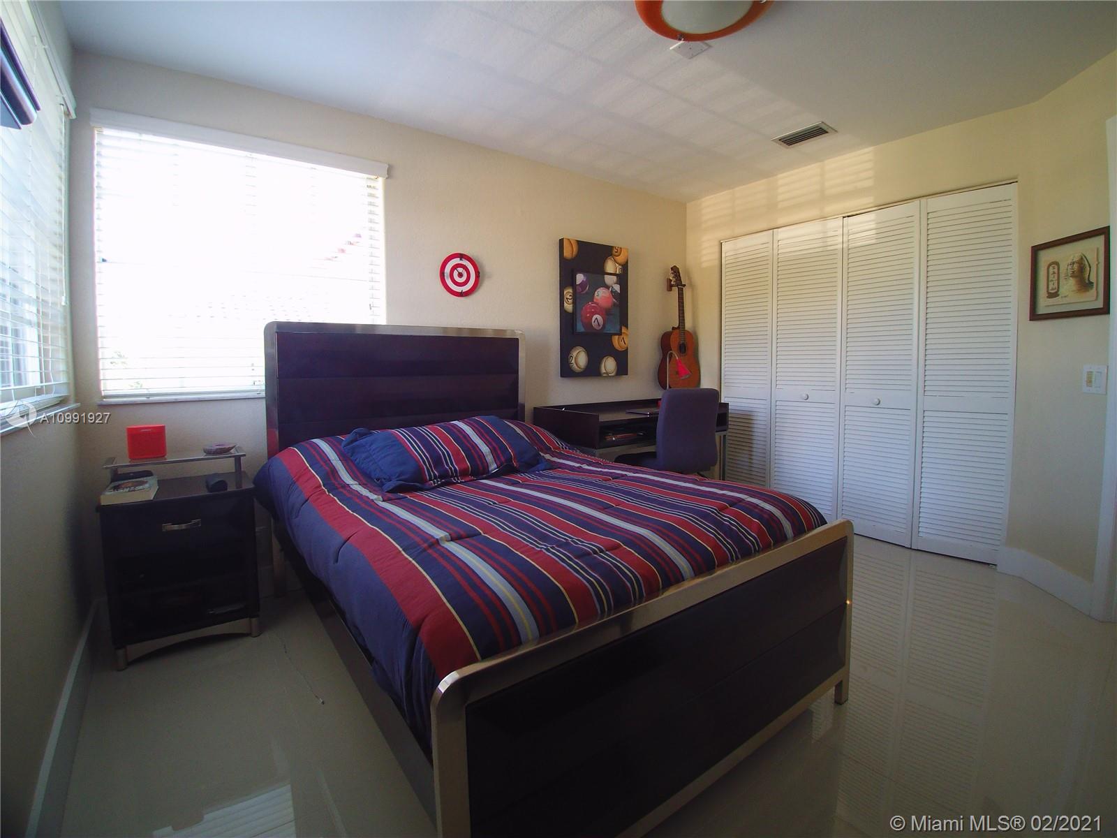 1055 San Luis Rey Weston, FL 33326 - Photo 26 of 36 a bedroom with a bed and a window