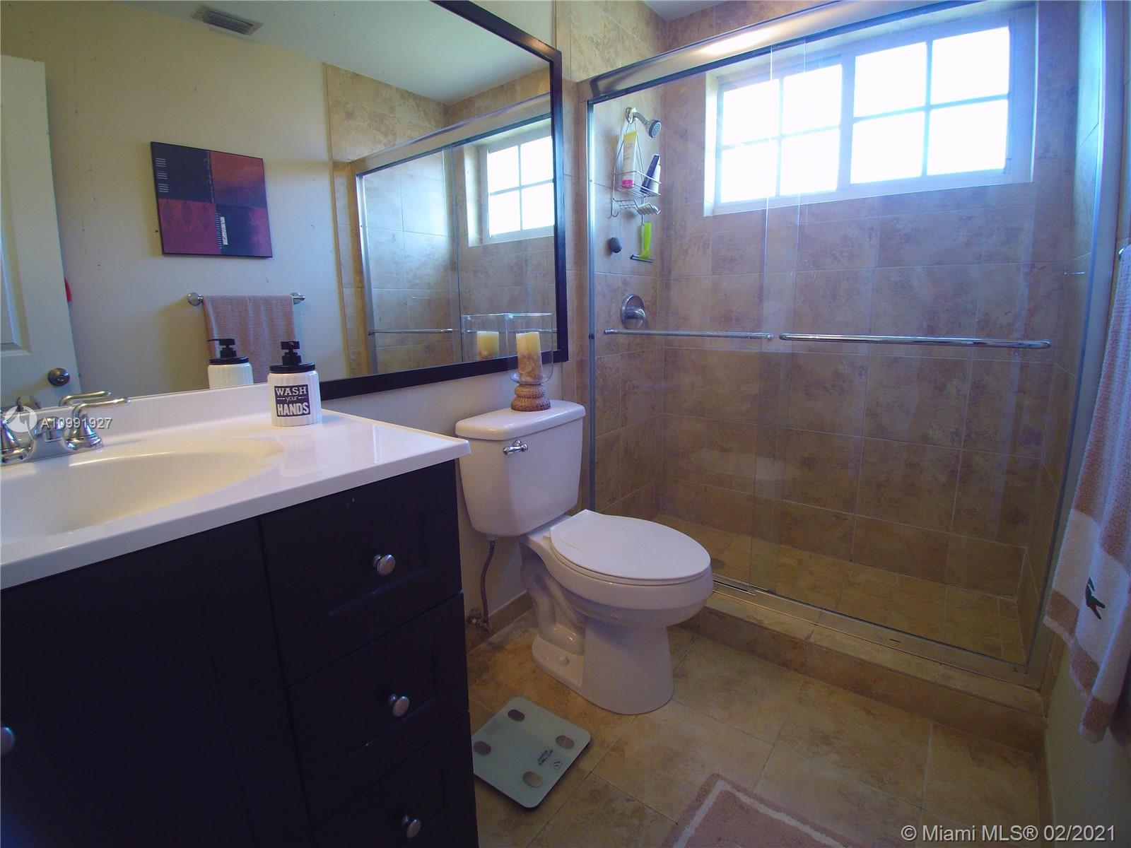 1055 San Luis Rey Weston, FL 33326 - Photo 30 of 36 a bathroom with a sink a toilet and shower