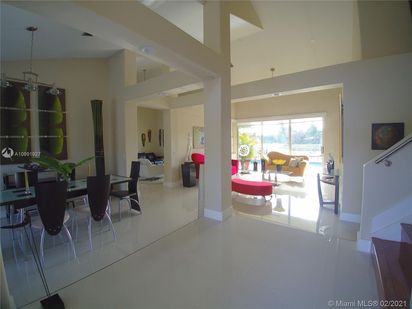 1055 San Luis Rey Weston, FL 33326 - Photo 4 of 36 a living room with furniture and a flat screen tv