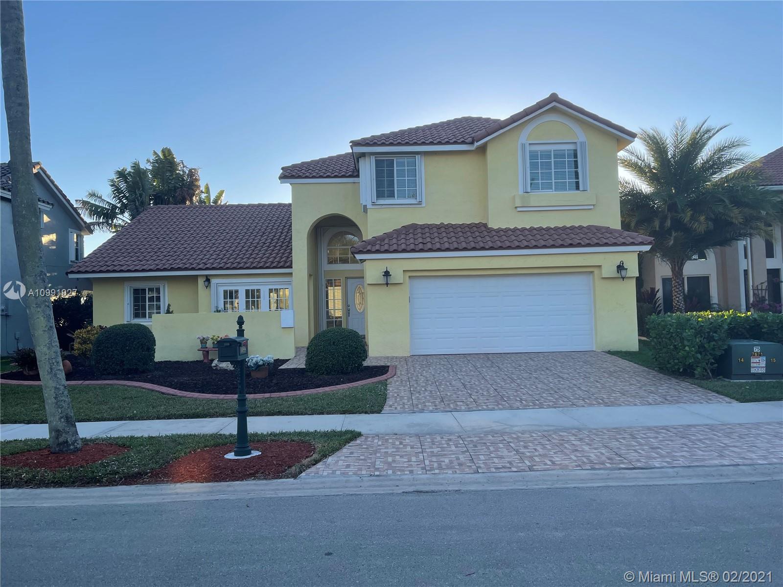 1055 San Luis Rey Weston, FL 33326 - Photo 36 of 36 a front view of a house with a yard and garage