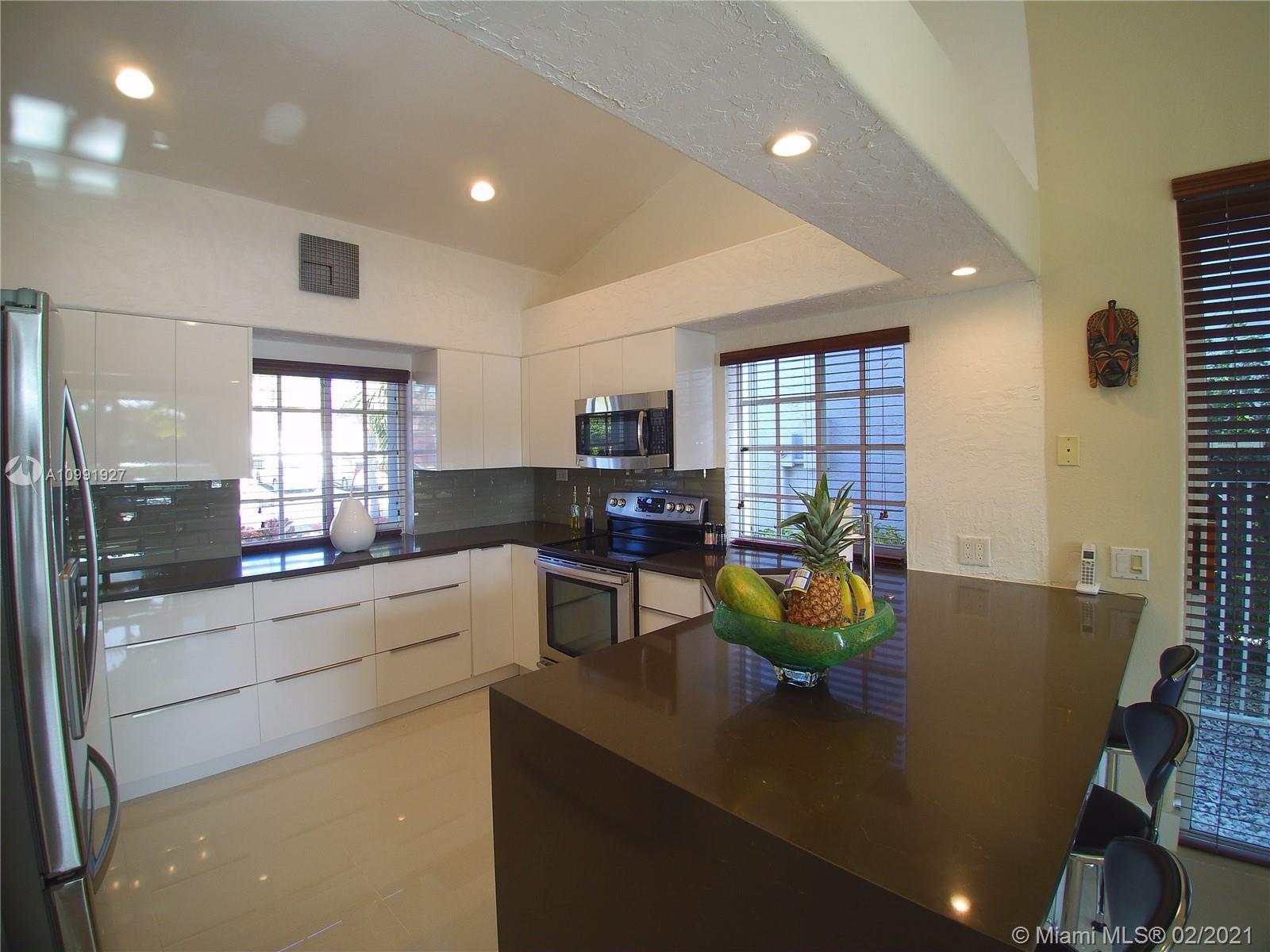 1055 San Luis Rey Weston, FL 33326 - Photo 8 of 36 a kitchen with sink refrigerator and window