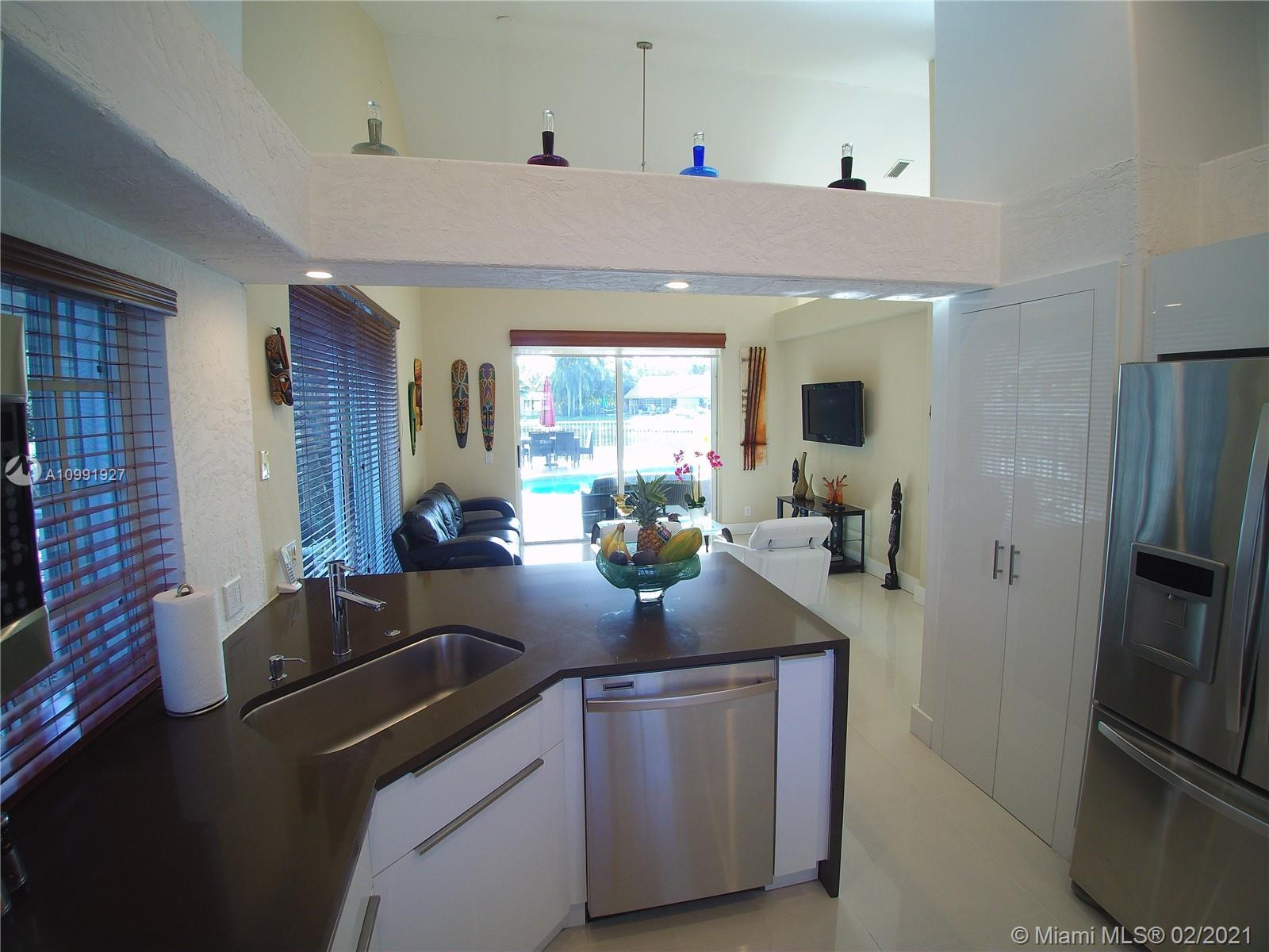 1055 San Luis Rey Weston, FL 33326 - Photo 9 of 36 a kitchen with sink refrigerator and window