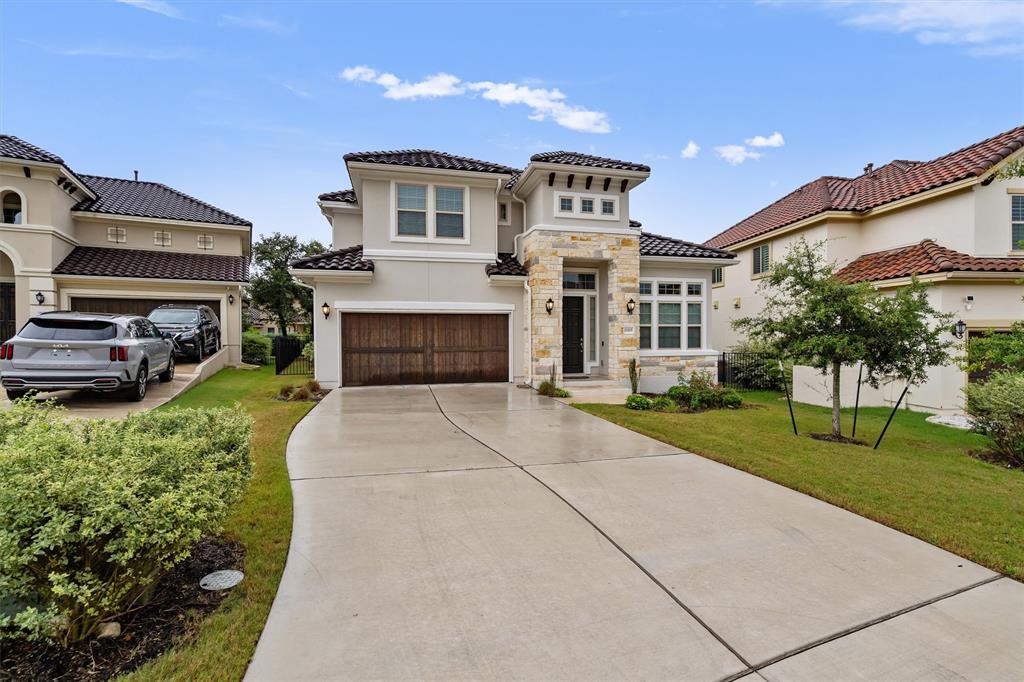 11905 Bayshore Cove, Unit 127 Austin, TX 78726 - Photo 1 of 35 a front view of a house with a yard and a garage