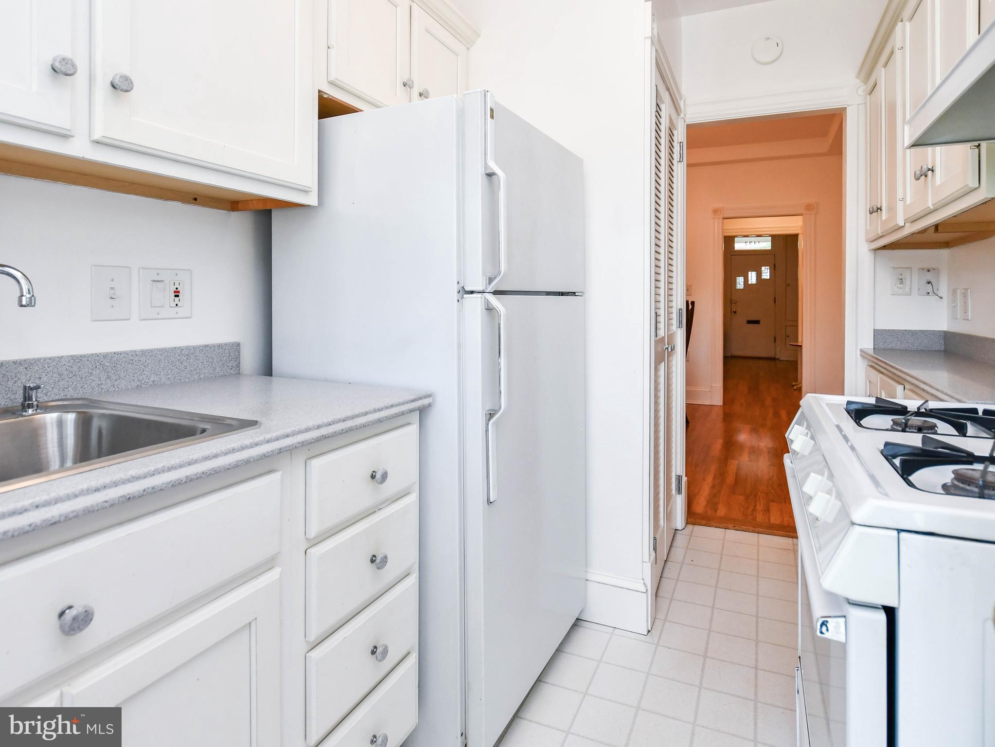 1432 C Street Southeast Washington, DC 20003 - Photo 13 of 48 a kitchen with white cabinets and white appliances