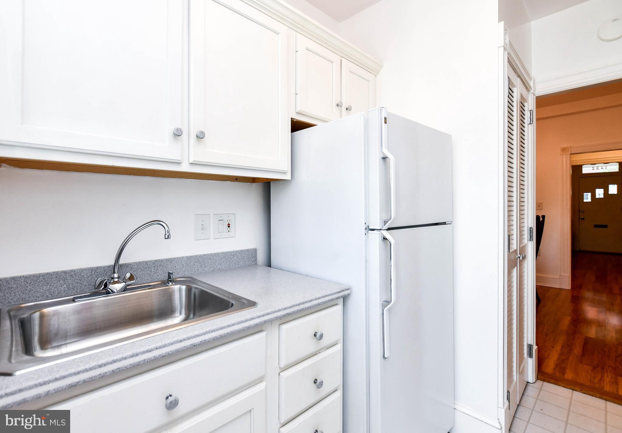 1432 C Street Southeast Washington, DC 20003 - Photo 14 of 48 a kitchen with stainless steel appliances granite countertop a sink and a refrigerator