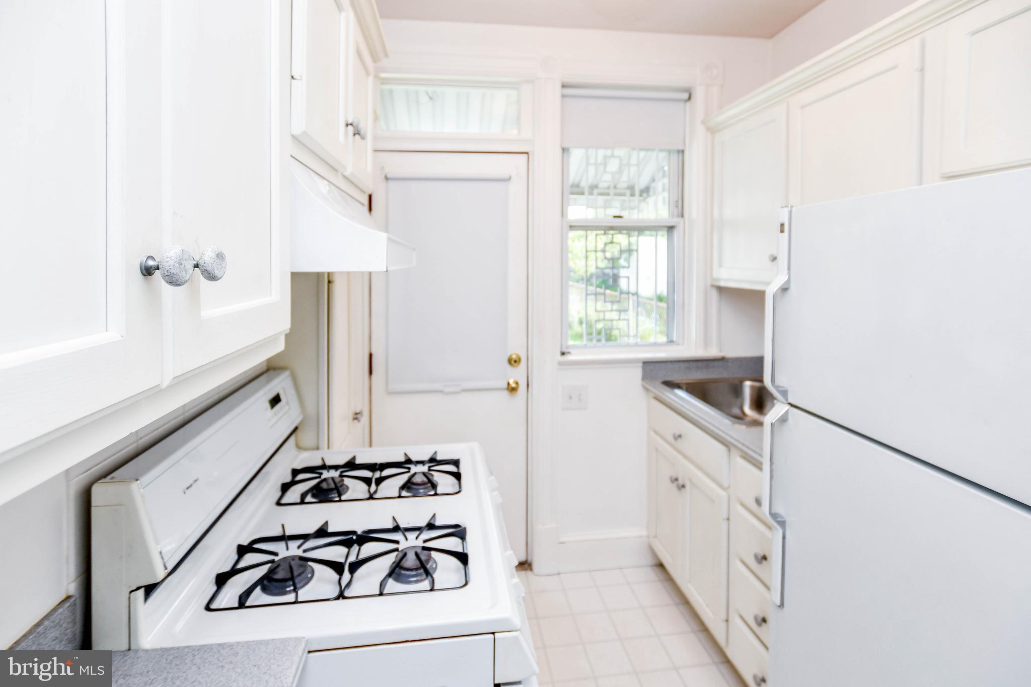 1432 C Street Southeast Washington, DC 20003 - Photo 15 of 48 a kitchen with granite countertop a sink stove and refrigerator
