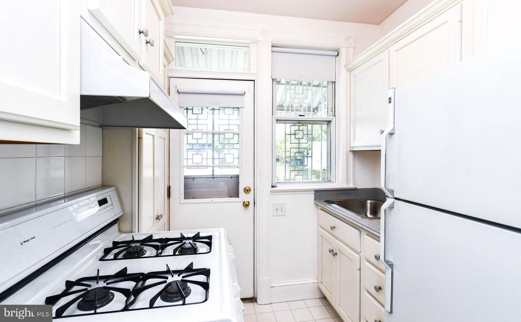 1432 C Street Southeast Washington, DC 20003 - Photo 16 of 48 a kitchen with a refrigerator a sink and wooden cabinets