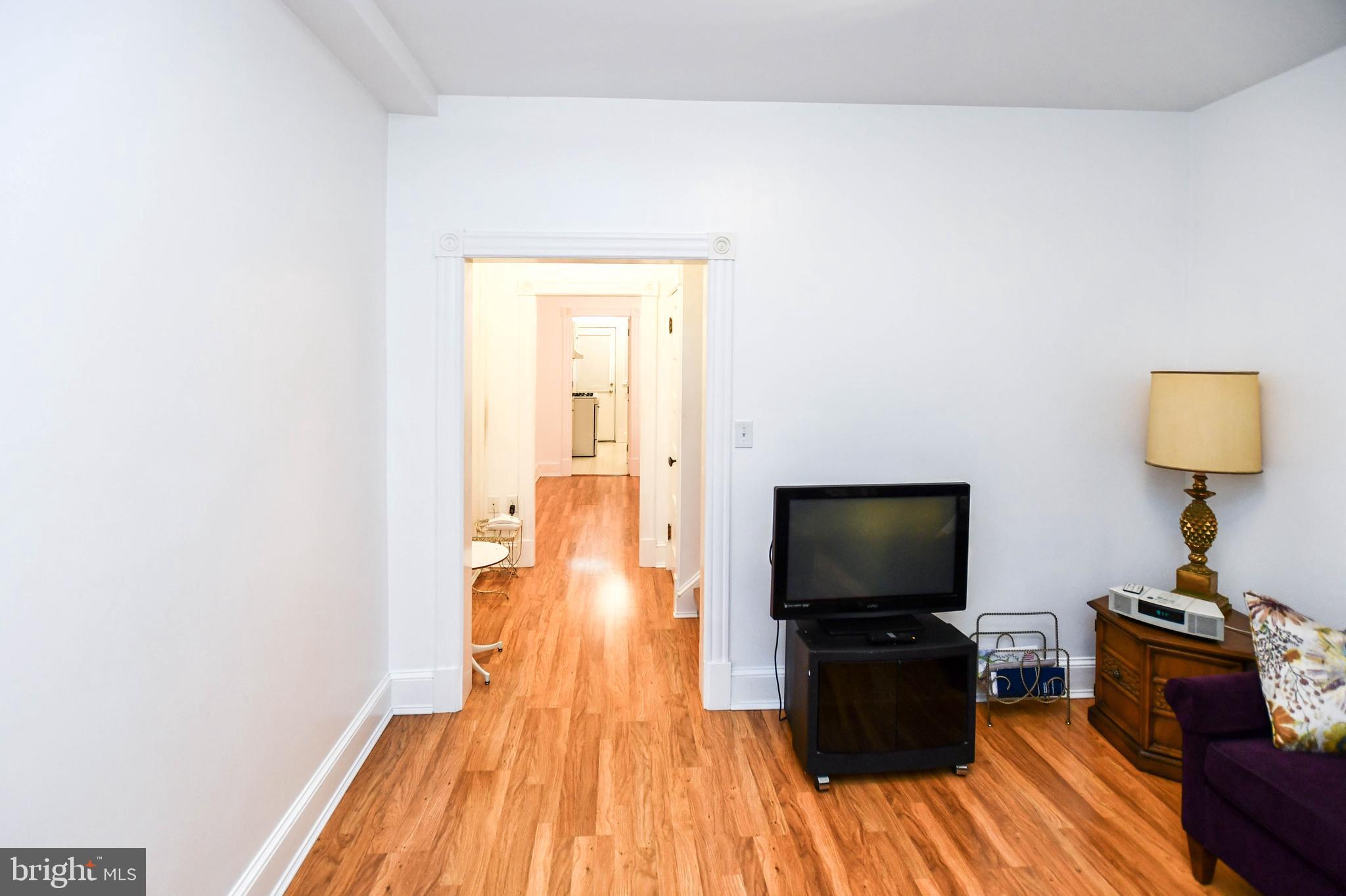 1432 C Street Southeast Washington, DC 20003 - Photo 8 of 48 a living room with a flat screen tv on dresser and a wooden floor