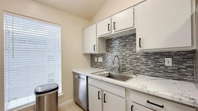 a kitchen with stainless steel appliances a sink a stove and cabinets