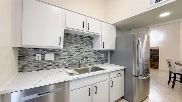 a kitchen that has a sink cabinets counter space and appliances