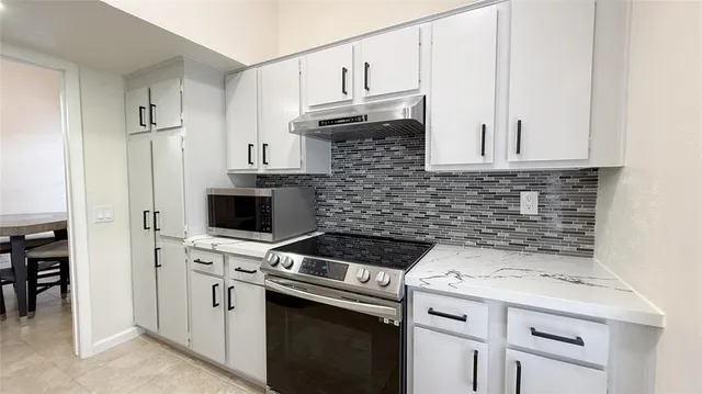 a kitchen with cabinets stainless steel appliances and a sink